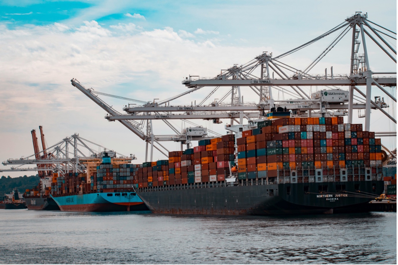 Container ship loading at busy cargo port